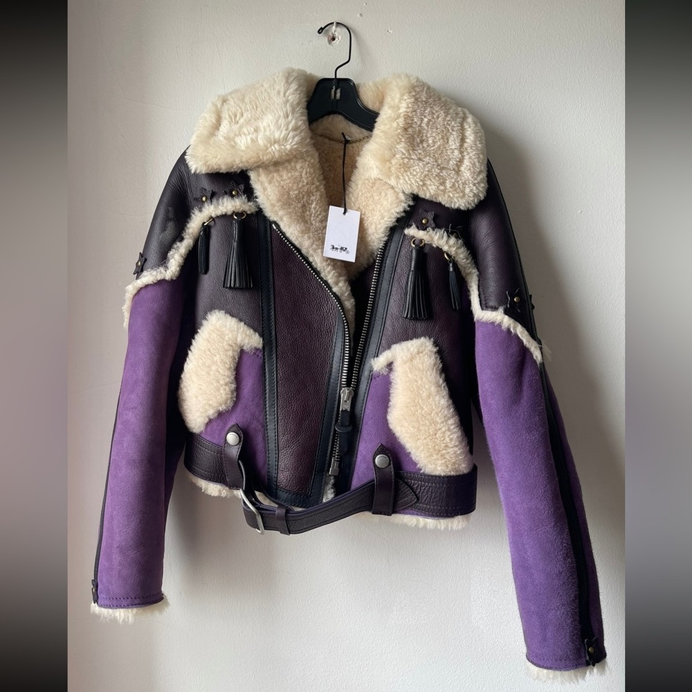 - 100% lamb leather and shearling
- Zip closure
- Slip pockets
- Adjustable belt